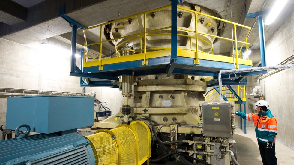 Metso expert standing in front of a mining crusher