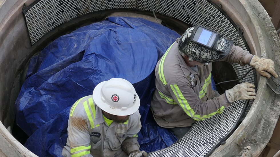 Zwei Männer arbeiten an Brecher-Verschleißteilen.
