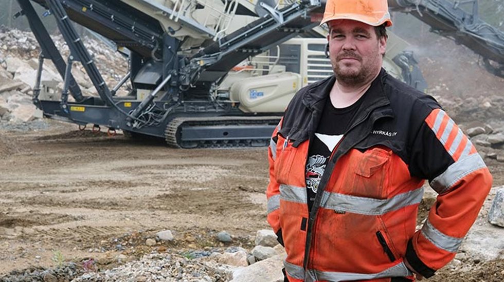 Mies louhoksella, Lokotrack LT220D-karamurskain-seulalaitos taustalla. 