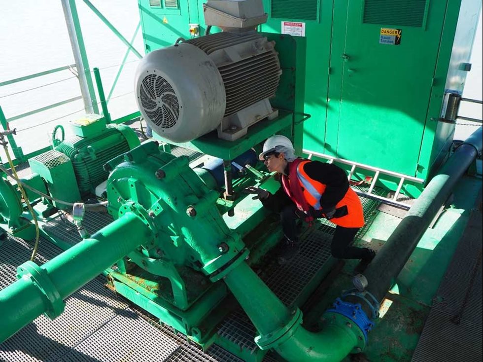 Une femme inspectant une pompe.