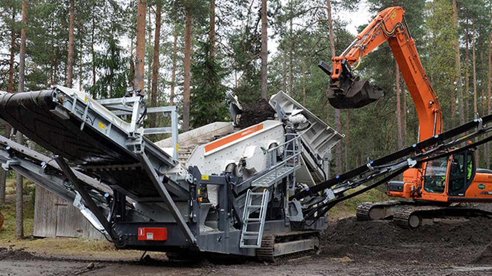 Seula ja kaivinkone metsämaisemissa.