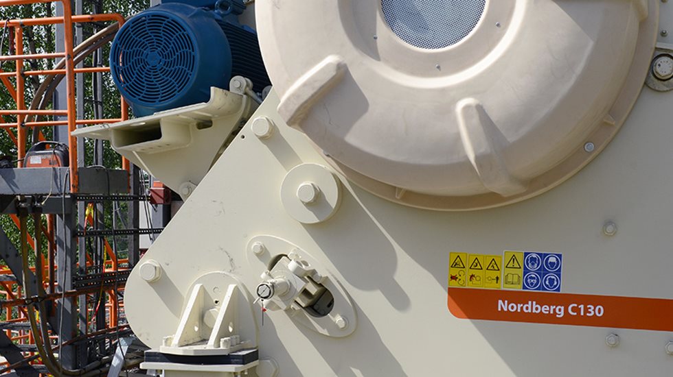 Um homem olhando para um britador de mandíbulas Nordberg série C.