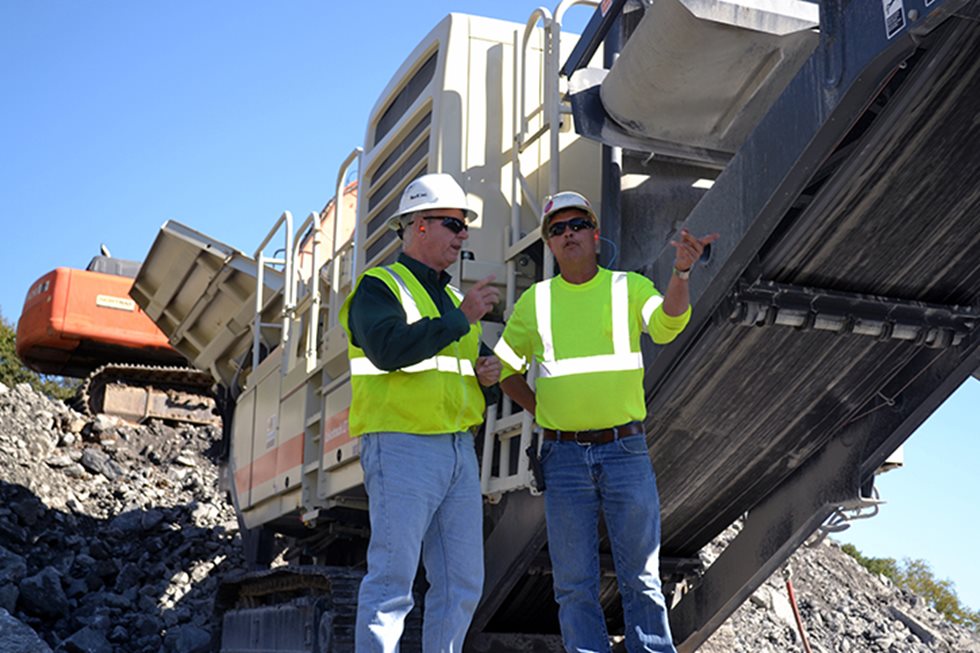 Two men standing next to Lokotrack. 