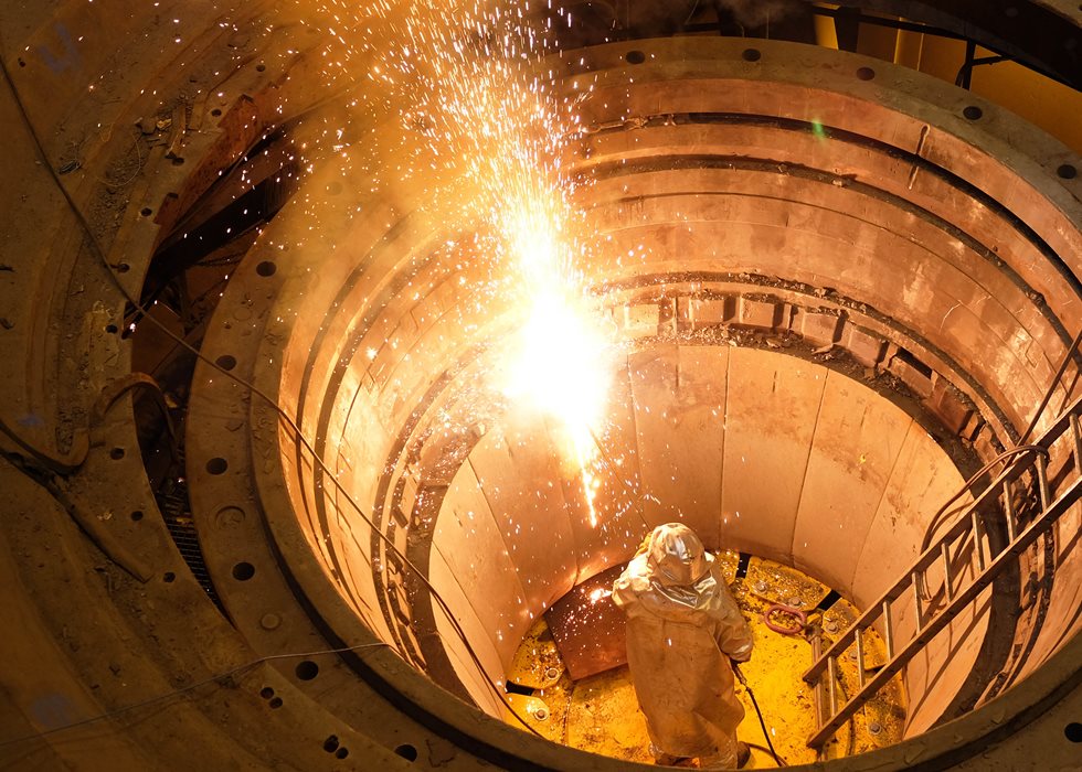 A man flame-cutting crusher segments.