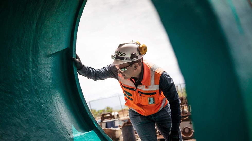 A man looking through a crusher wear part.