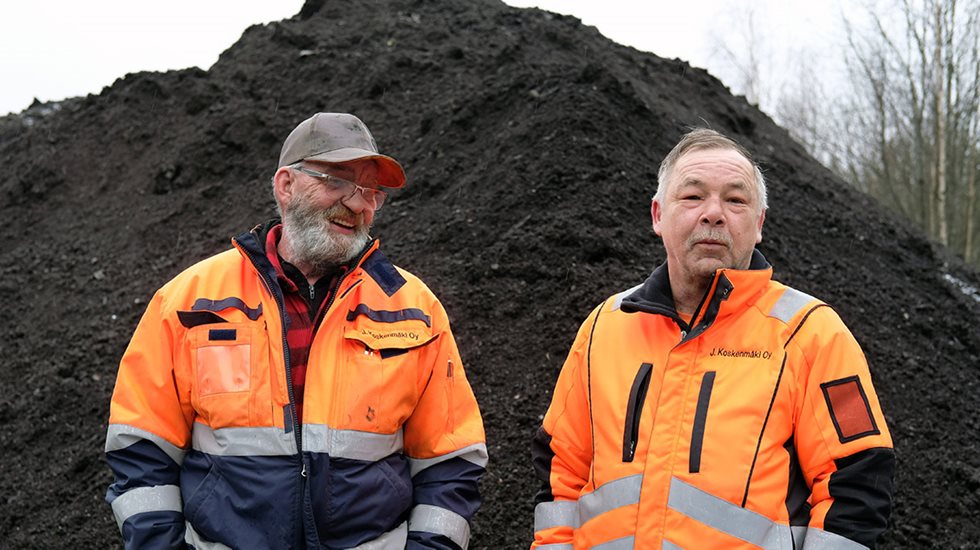 Kaksi miestä multakasan edesssä.