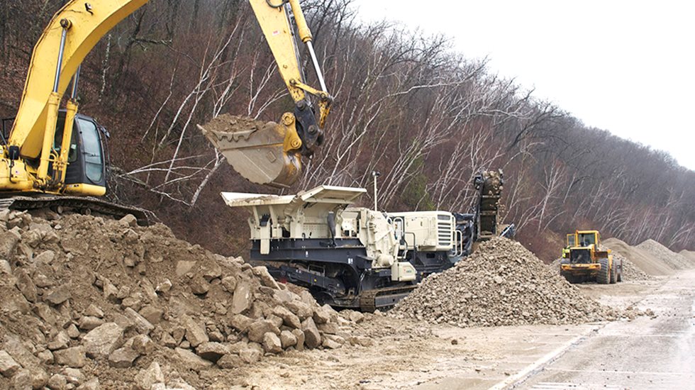 An excavator feeding a Lokotrack.