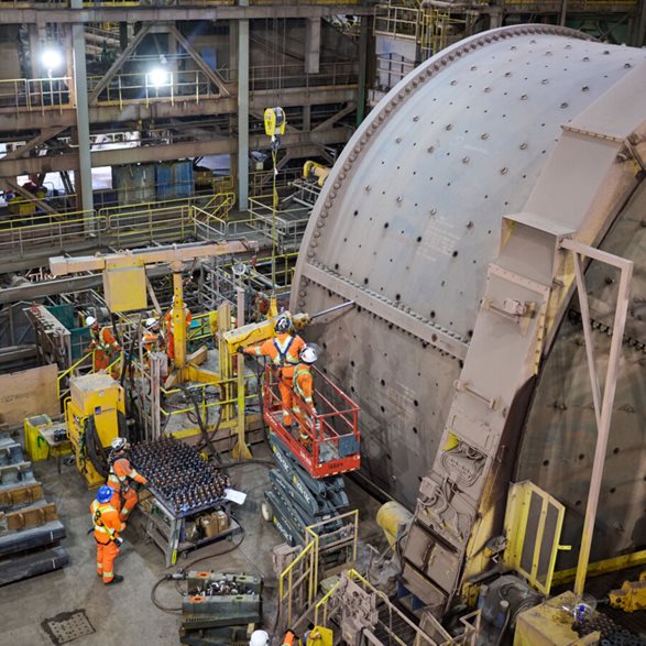 Metso reline team in safety gear removing bolts off a grinding mill and stagging mill linings for a relining event at Bloom Lake Mine in Quebec