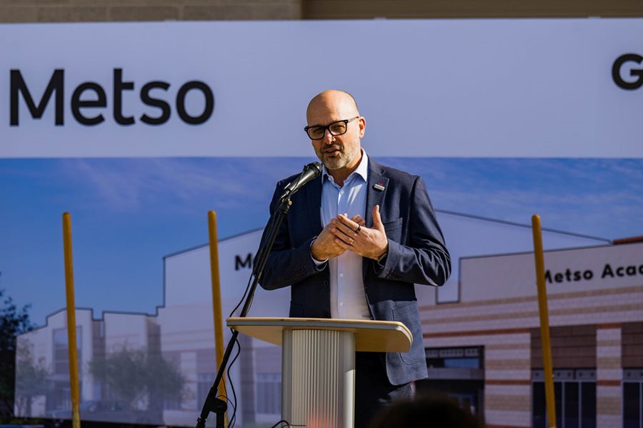 Man speaking into a microphone in front of a podium