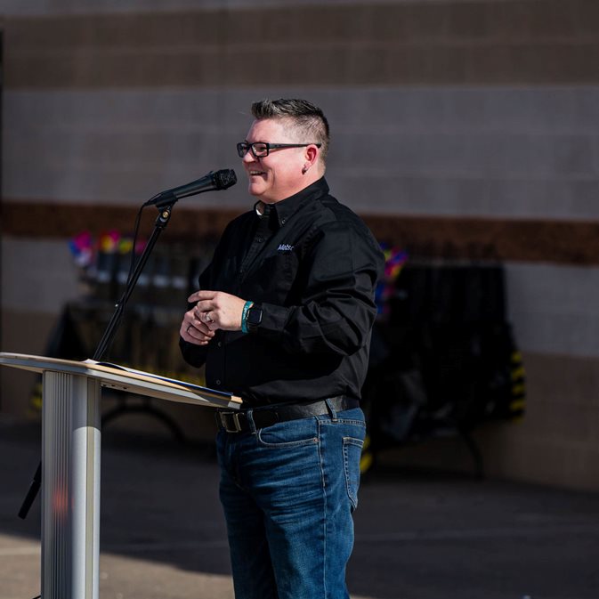 Woman standing at a podium speaking into a microphone