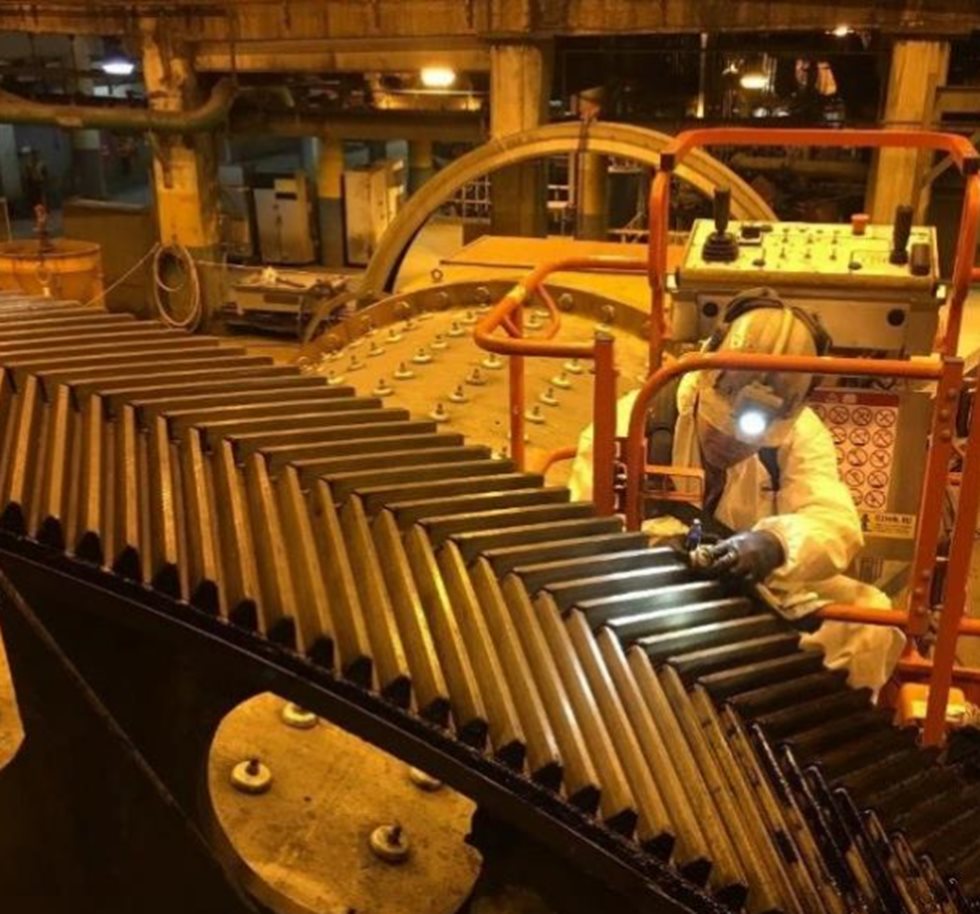 Man doing digital gear inspection of a grinding mill ring gear.