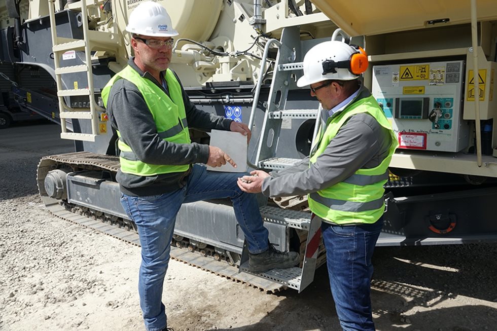Two workmen in front of LT106 crusher at the at Bierbrauer & Sohn site. 