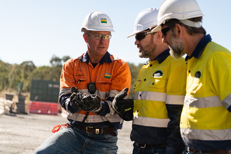 Three men talking at a quarry.