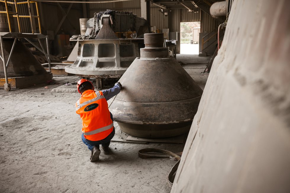 A person examining a worn crusher liner. 